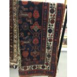 Rugs: 19th cent. Kazak style rug with dark blue ground and filled with stylized geometric and floral
