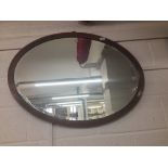 20th cent. Mahogany inlaid oval mirror. Width 36ins.