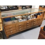 Early 20th cent. Oak and glazed haberdasher's display cabinet with fifteen graduated drawers, on