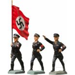 Drei Lineol SS Figuren mit Fahnenträger und marschierendDrei politische SS-Figuren, Lineol, 7 cm-