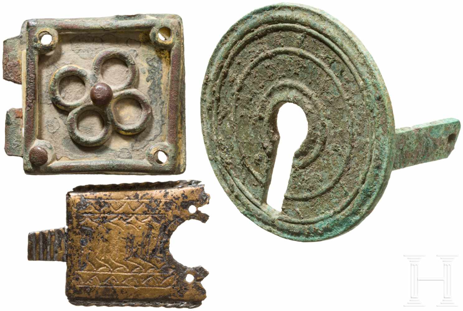 Drei Bronzebeschläge, römisch, bis 15. Jhdt.Darunter eine runde, römische Schlüsselloch-Abdeckung