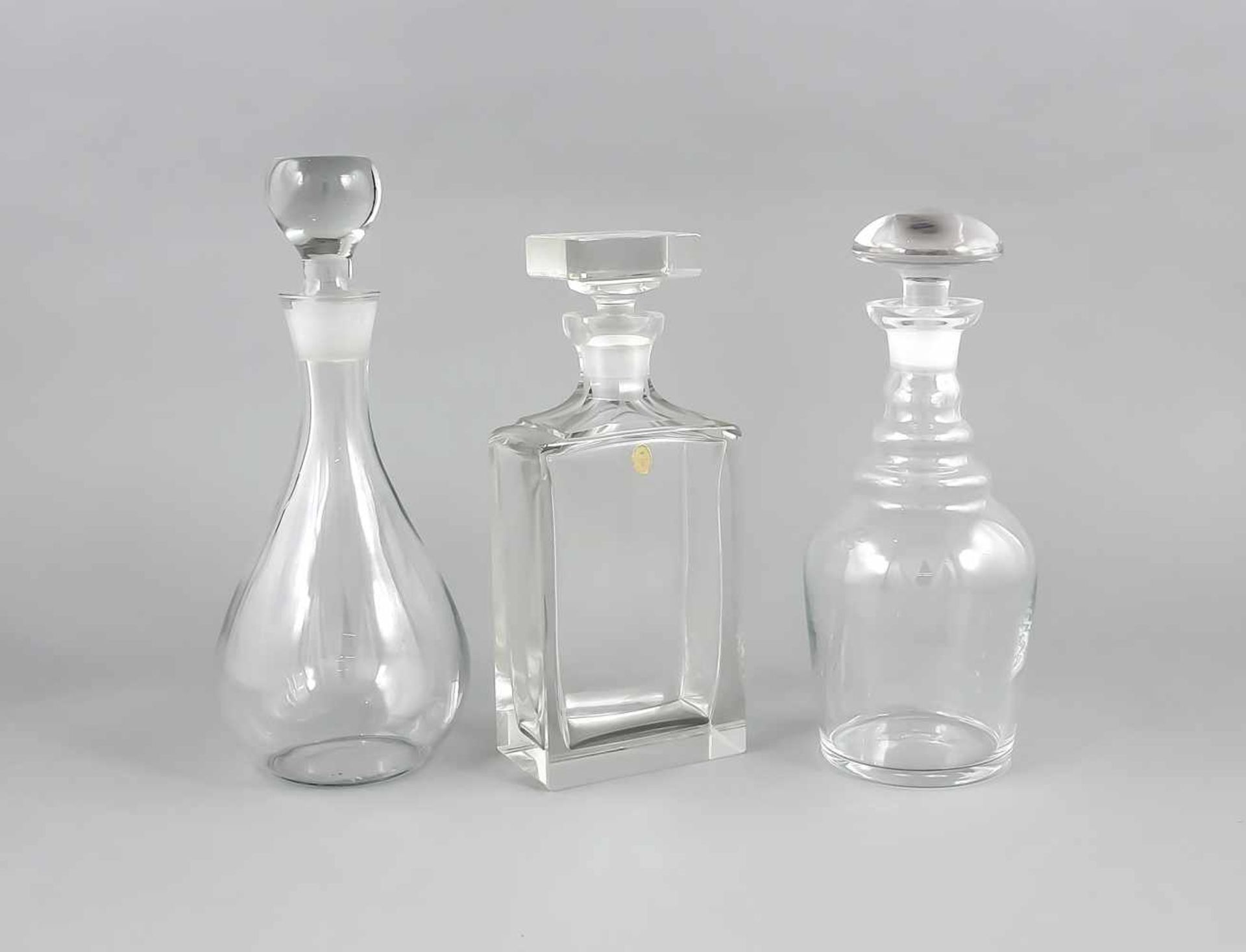 Drei Karaffen, 20. Jh., unterschiedliche Formen und Größen, klares Glas, H. bis 30 cmThree