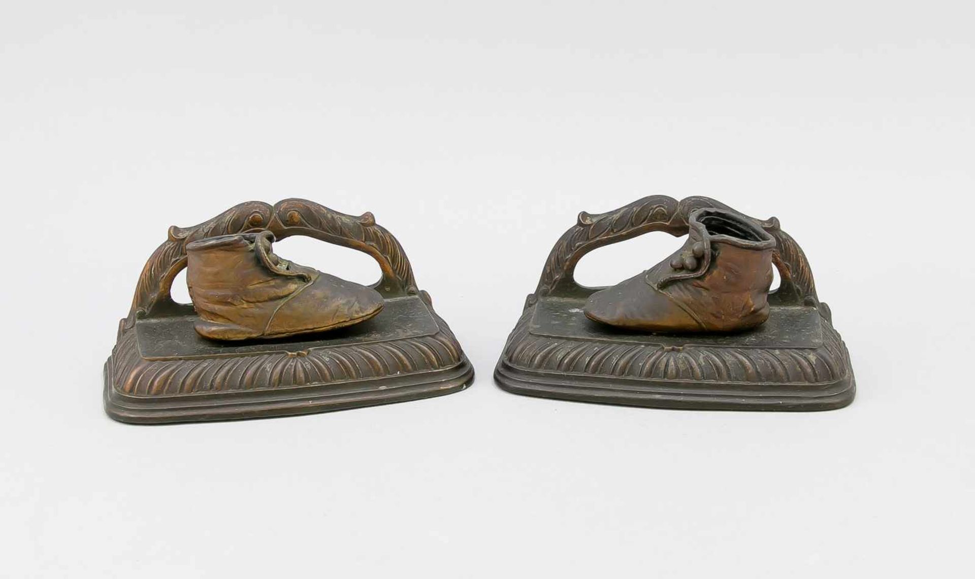 Paar Buchstützen, 19. Jh., Rotguss. Profilierte Sockel mit ornamentiertem Bügel, daraufjeweils ein
