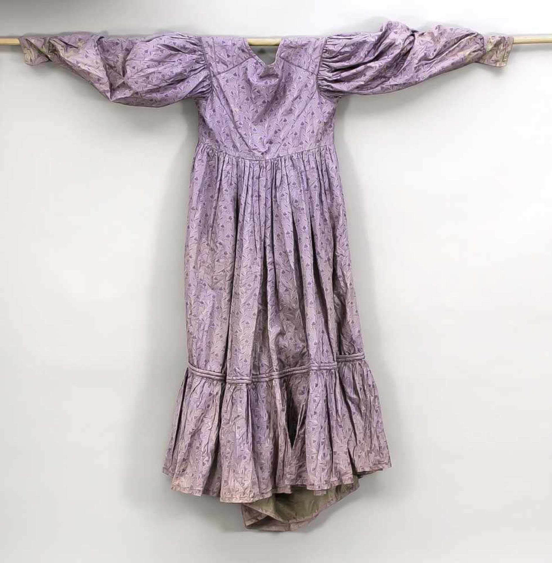Biedermeierkleid, 19. Jh., aus einem brokatähnlichen Stoff in Violett mit Blumenmuster,