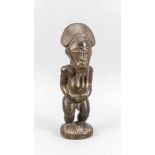 Figur eines Stehenden mit Dreispitz-Bart, Westafrika. Holz mit dunkler, leicht glänzenderOberfläche.