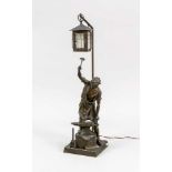Figürliche Lampe um 1900, Eisen und Glas. Quadratischer Sockel, darauf ein Schmied mitAmboss, ein