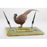 A large early 20th century cold painted bronze cock pheasant, mounted upon an onyx desk stand with