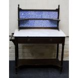 An Edwardian marble top washstand with blue floral tile upstand over single frieze drawer on ring