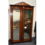 An Edwardian rosewood, marquetry inlaid and strung double wardrobe, the shaped pediment with urn and