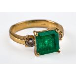 A three stone half hoop emerald and diamond ring, the square step cut emerald in four claw mount