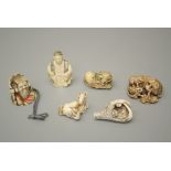 A group of six tagua and other netsuke, including cat with carp, horse and rat, eagle talon and