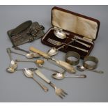 A cased silver scroll terminal spoon and fork, a silver cigarette case, pair of serviette rings,