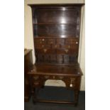 A part 19th century oak dresser of small proportions, the rack fitted open shelves, pigeon holes and