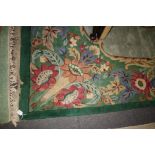 A 20th century Chinese wool carpet, woven with a bold central floral reserve with a conforming guard