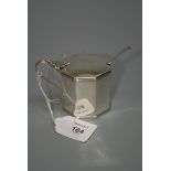 A George III mustard pot, octagonal with reeded borders and octagonal thumbpiece to hinged cover,