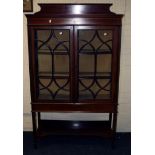 An Edwardian mahogany, satinwood strung vitrine, the shaped upstand over rectangular top with a