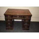 A late Victorian oak twin pedestal desk, the rectangular top set with red gilt tooled scriber over
