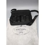A black leather Prada shoulder bag, number B5990, with dust bag and authenticity certificate card