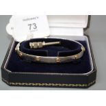 A two colour 18ct gold Cartier-style screw head bangle, the plain polished white gold bangle with