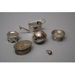 A miniature white metal box fashioned as a Middle Eastern hexagonal table, a miniature watering can,