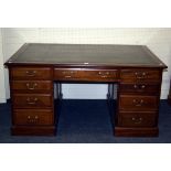 An Edwardian mahogany partner's desk, the rectangular top set with gilt tooled green hide scriber