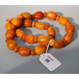 A butterscotch amber bead necklace of irregular graduated oval beads with circular disc spacers 78cm