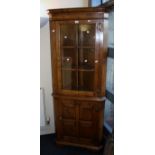 A bespoke reproduction oak floor standing corner cupboard, the moulded cornice over a glazed door