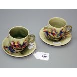 A pair of circa 1950's Moorcroft Orchid coffee cups and saucers, each with multi coloured blooms