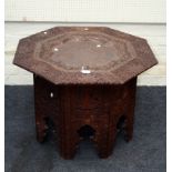 A late 19th century Middle Eastern carved hardwood octagonal table, the top with pierced copper
