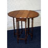 An early 20th century oak gateleg occasional table, the oval top with twin flaps on bobbin turned