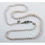 A row of slightly graduated pearls to a diamond set open work lozenge clasp, 50.5cm length, pearls