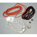 A graduated double row coral bead necklace together with another coral bead necklace, a sapphire and