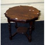 An Edwardian oak occasional table, the circular serpentine top on ring turned and block supports