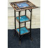 An aesthetic period cane three tier occasional table set with two Minton tiles decorated with