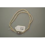 A two row graduated cultured pearl necklace, to a cultured pearl and paste cluster clasp, 40cm