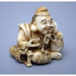 A 19th century Japanese carved ivory netsuke of a seated smiling man, with string tied hat and