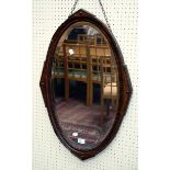 An Edwardian oak wall mirror with oval architectural beaded frame and bevelled plate, 51 x 60cm