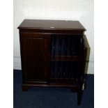 A mahogany record cabinet, the moulded edge top over a pair of panel doors enclosing a divided