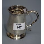 A George III mug, baluster form, leaf-capped double scroll handle, spreading circular foot,