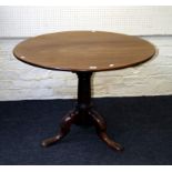 A George III mahogany tripod table, the circular tilt top on gun barrel column, short cabriole