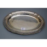A Victorian meat dish, shaped oval with gadrooned border, and crest engraved to side, London 1856 by