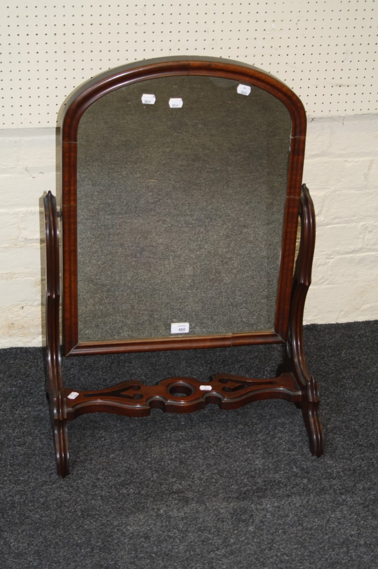 An Edwardian mahogany toilet mirror, the cushion framed arched plate on a pierced support, 82 x