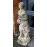 A well weathered composite garden statue, modelled as a young woman, emblematic of Spring, holding a