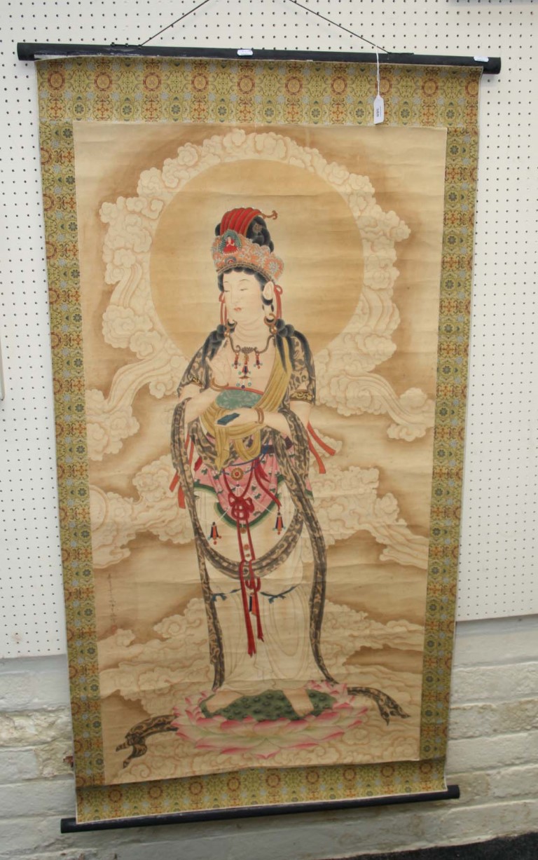 A Chinese 20th century painted scroll, depicting Guan Yin on a lotus socle with silk brocade border,