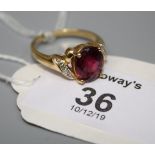 A single stone pink tourmaline ring, the chequerboard oval cut stone in four claw mount with diamond