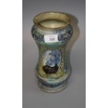 An Italian Albarello jar painted with a panel of a monk in profile within leafy borders, 25cm high