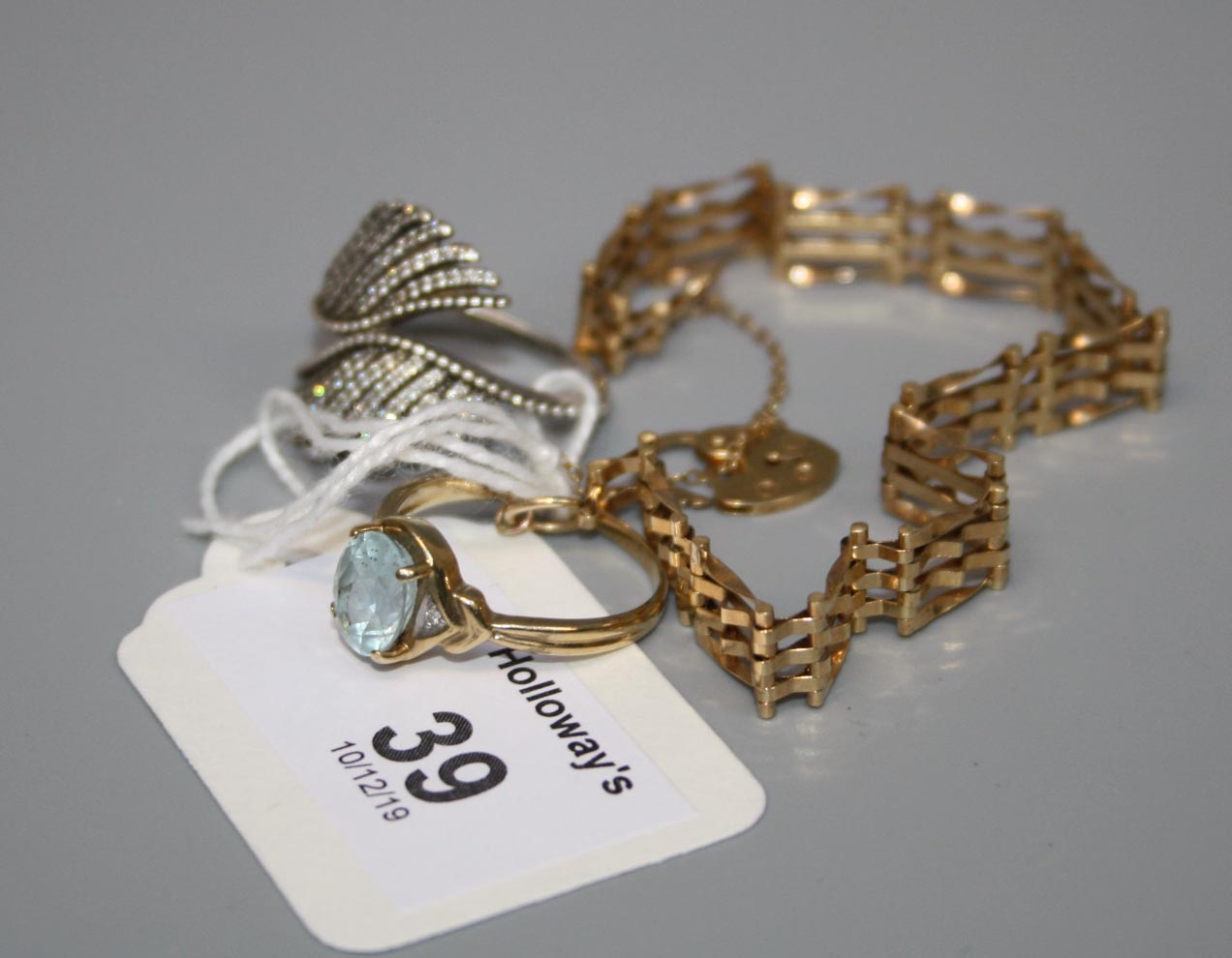 A single stone aquamarine ring, a 9ct gold gatelink bracelet and one further ring, Gold 6.9g