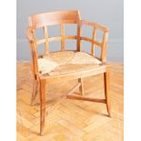 A Heals of Tottenham Court Road style limed oak desk chair with low back, rush seat and splay legs