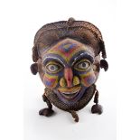 A carved and beaded African 'Bamileke' mask, with woven and string hair, 38cm long