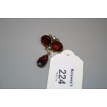 A 19th century three stone garnet and rose diamond brooch, the garnets with closed back setting